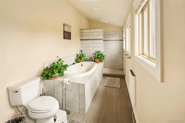 a spacious bathroom with a tub sink and mirror
