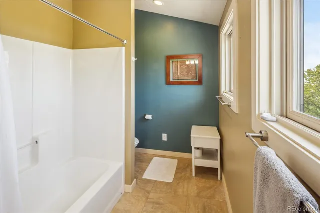 a bathroom with a tub sink and mirror