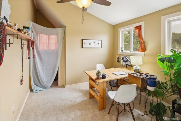 a room with a table chairs and a refrigerator