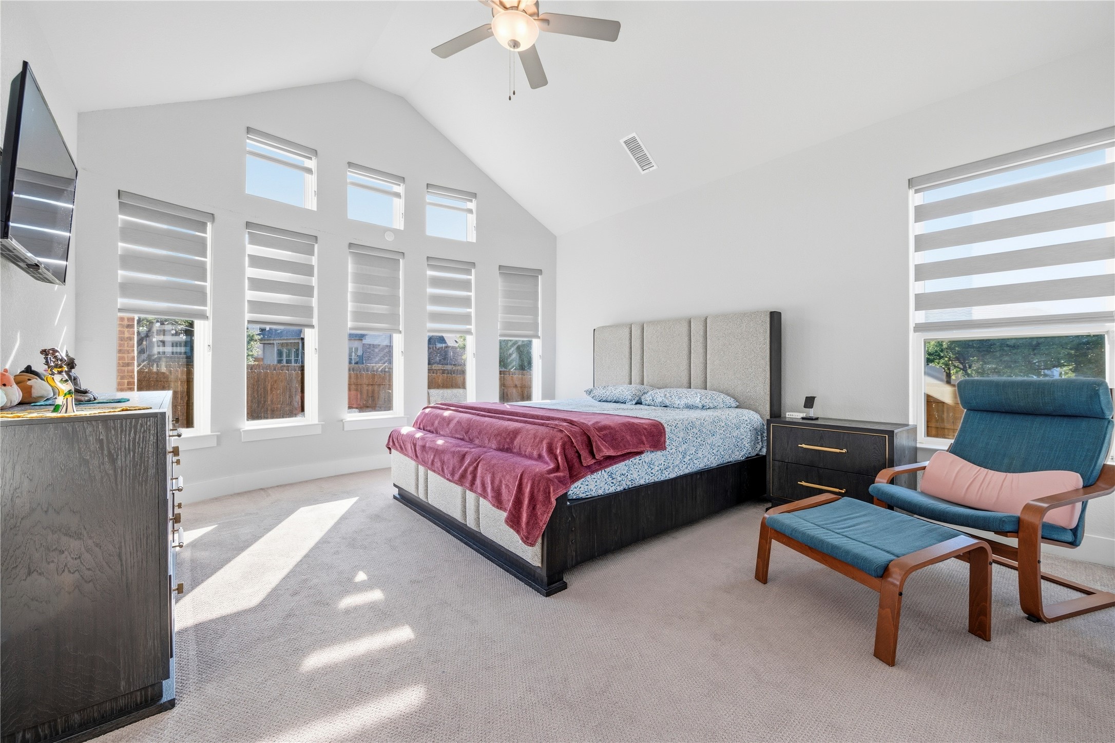 105 Autumn Oak Way Georgetown, TX 78628 - Photo 23 of 40 Vaulted ceiling bedroom with multiple windows, individual window treatments, ceiling fan, and carpet flooring
