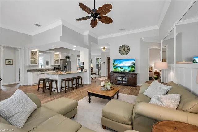 a living room with furniture kitchen view and a flat screen tv