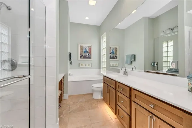 a spacious bathroom with a granite countertop sink mirror and bathtub