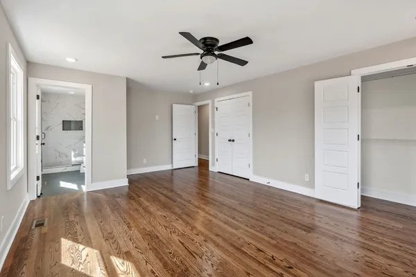 a spacious bathroom with a granite countertop sink a toilet a mirror and bathtub
