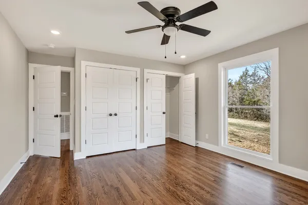 a view of a big room with wooden floor and windows
