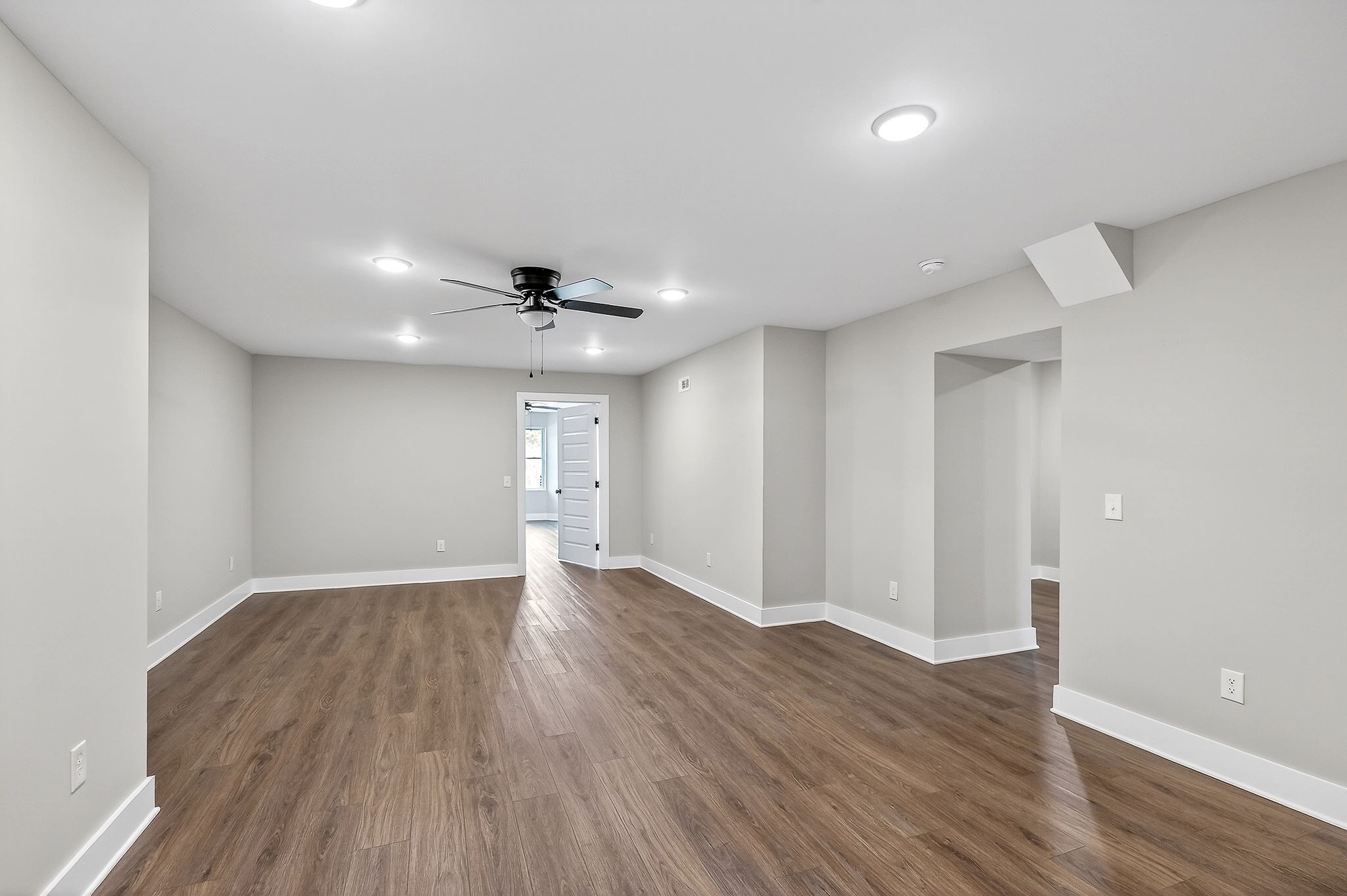 698 Mike Muncey Road McMinnville, TN 37110 - Photo 42 of 71 a view of an empty room with wooden floor and a ceiling fan