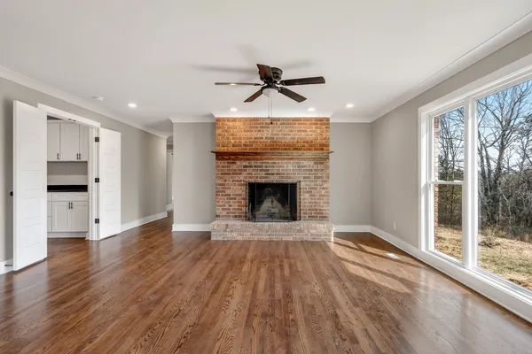 a view of empty room with wooden floor and window
