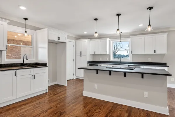a kitchen with granite countertop a stove a sink and a granite counter tops