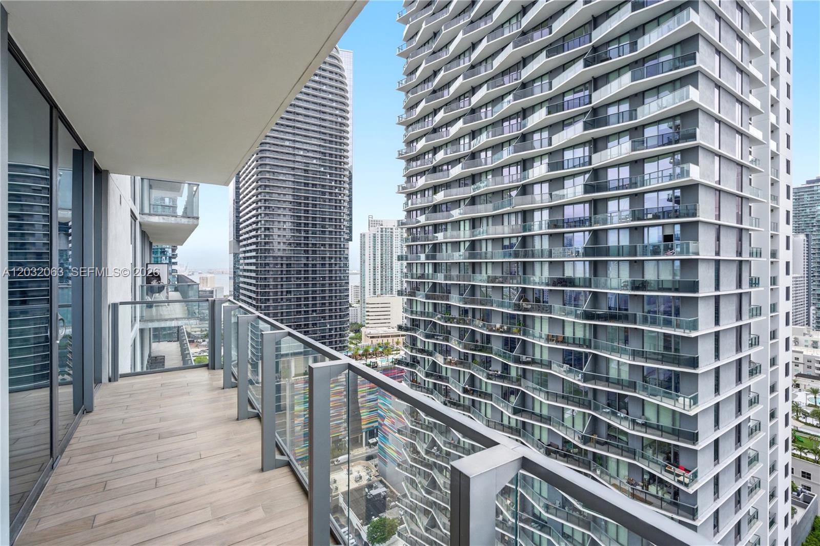 88 Southwest 7th Street, Unit 2302 Miami, FL 33130 - Photo 8 of 26 a view of a balcony with wooden floor and stairs