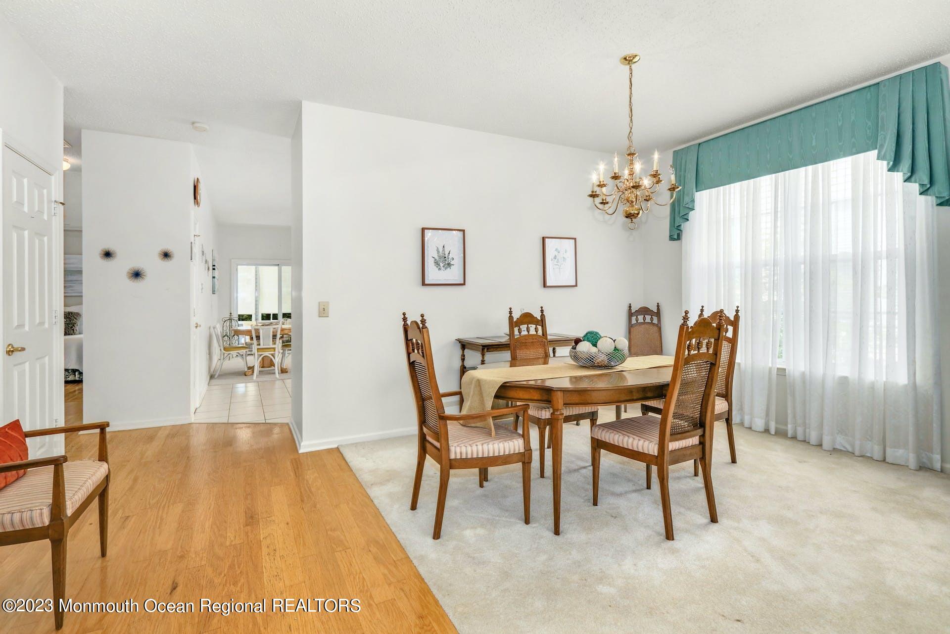 54 Sandpiper Road Barnegat, NJ 08005 - Photo 10 of 27 a dining room with furniture a chandelier and wooden floor
