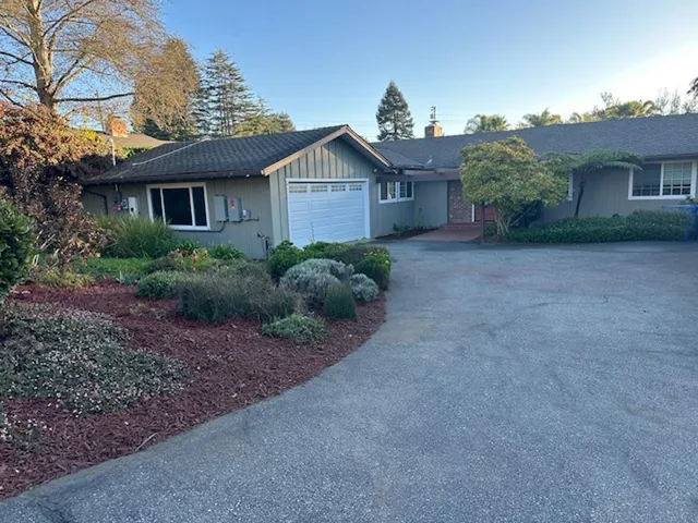 a view of a house with a yard and large tree