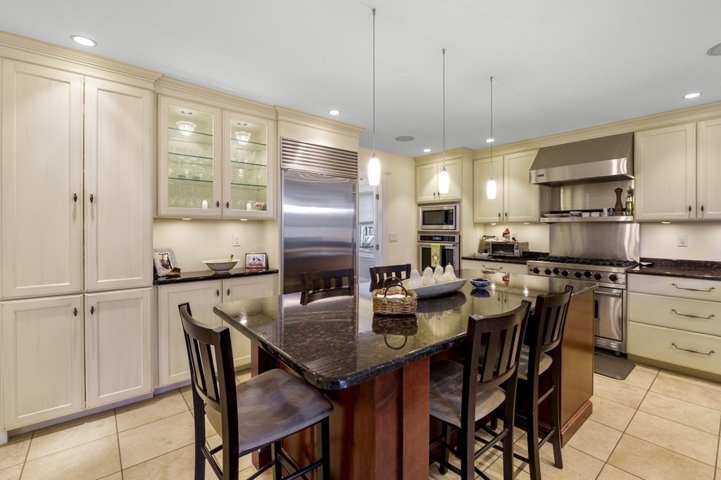 14 Homestead Road Marblehead, MA 01945 - Photo 23 of 41 a kitchen with stainless steel appliances granite countertop a stove a refrigerator a kitchen island a table and chairs