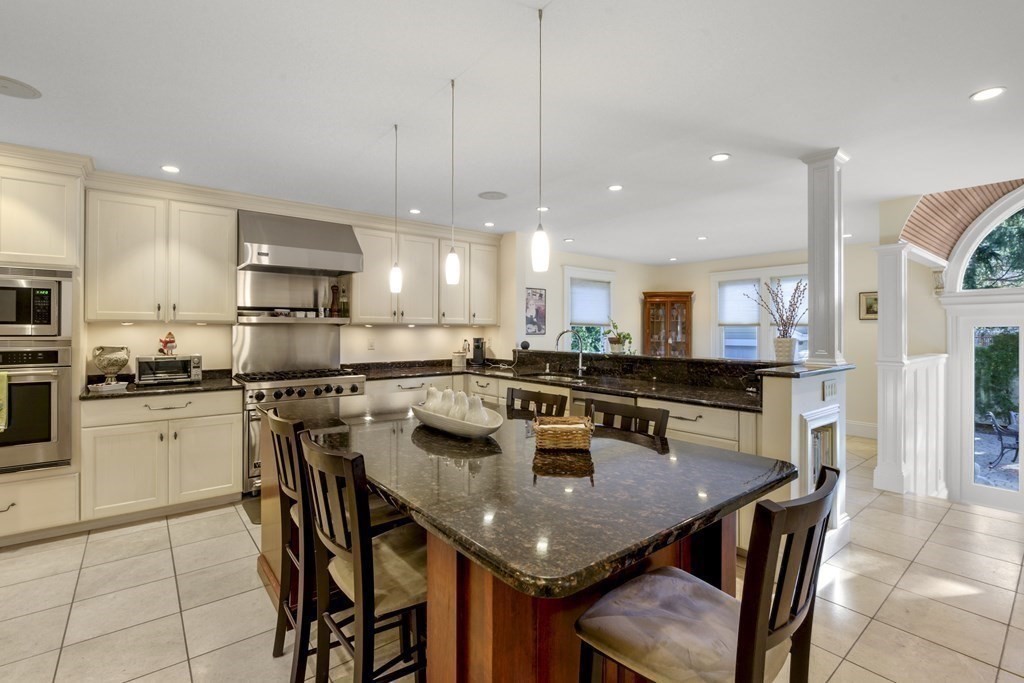 14 Homestead Road Marblehead, MA 01945 - Photo 24 of 41 a kitchen with stainless steel appliances granite countertop a stove a sink a kitchen island with a dining table and chairs