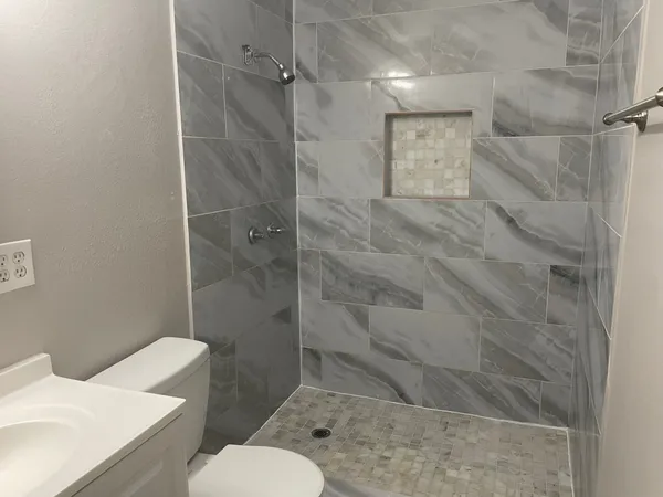 a view of a house with a wooden deck and a floor to ceiling window