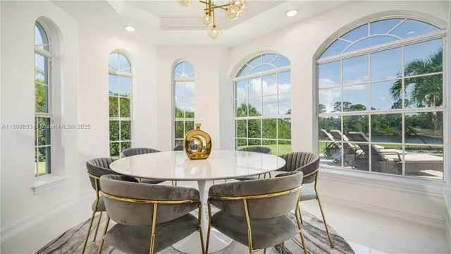 a dining room with furniture a chandelier and wooden floor