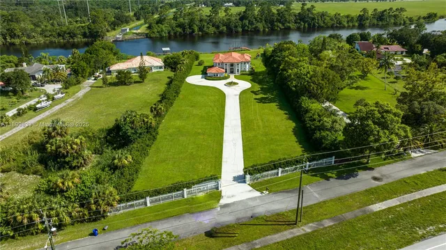 an aerial view of a house with a garden and lake view
