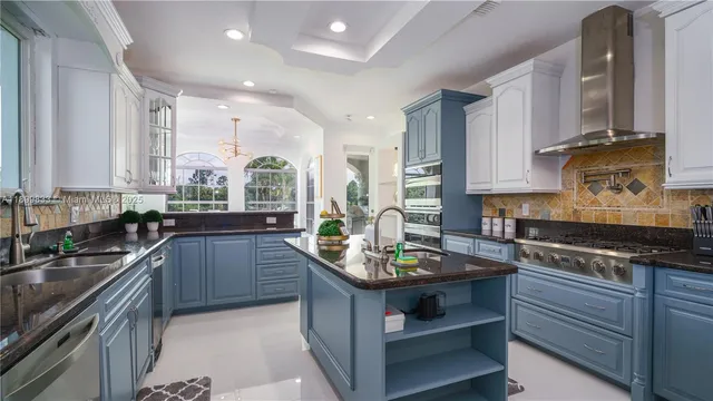 a kitchen with stainless steel appliances granite countertop a sink stove and cabinets