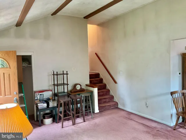 a view of a livingroom with furniture and staircase