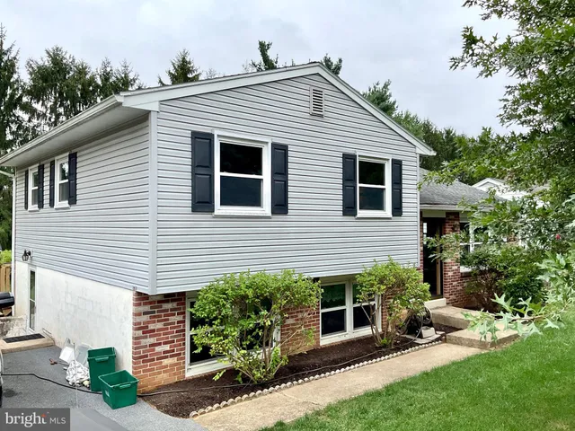 a view of a house with a yard and potted plants