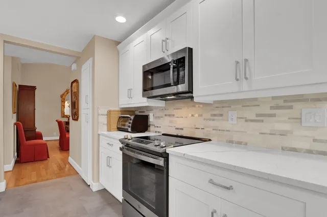 a kitchen with cabinets stainless steel appliances and wooden floor