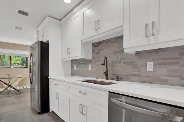 a kitchen with white cabinets and a sink