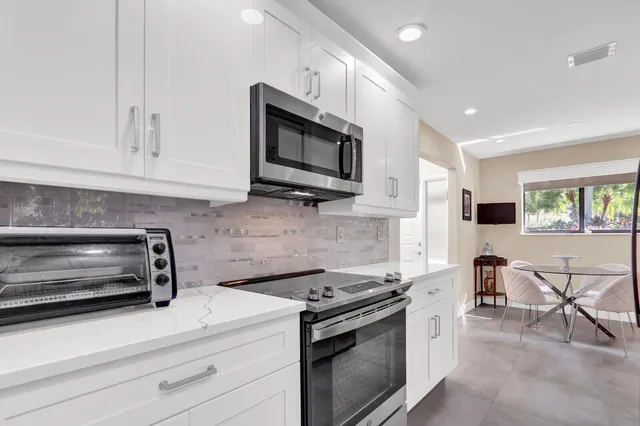 a kitchen with stainless steel appliances granite countertop a stove and a microwave