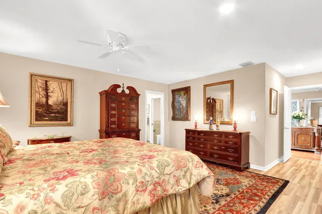 a spacious bedroom with a bed and dresser