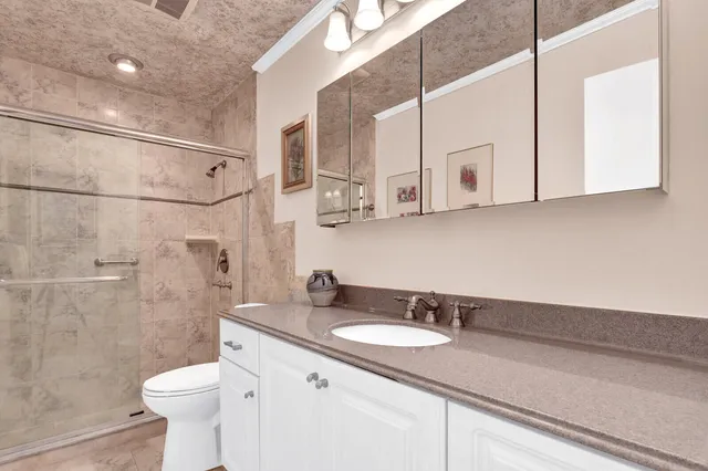 a bathroom with a sink a toilet and shower