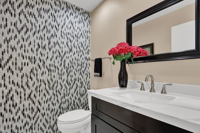 a bathroom with a sink a toilet and mirror