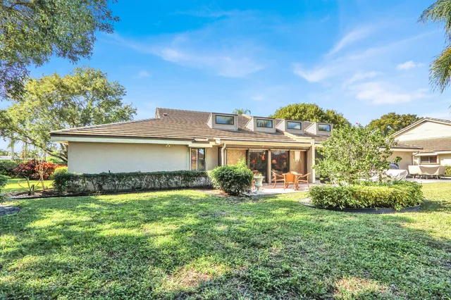 a view of a house with a big yard and potted plants