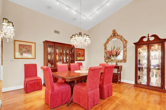 a view of a dining room with furniture a chandelier and wooden floor
