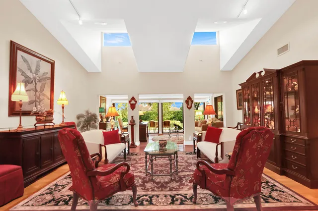 a living room with furniture a flat screen tv and a floor to ceiling window