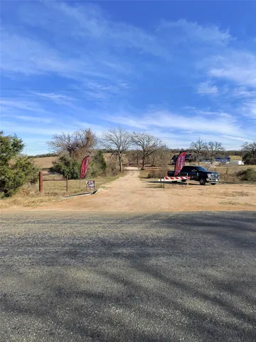 a view of dirt road with a building in the background