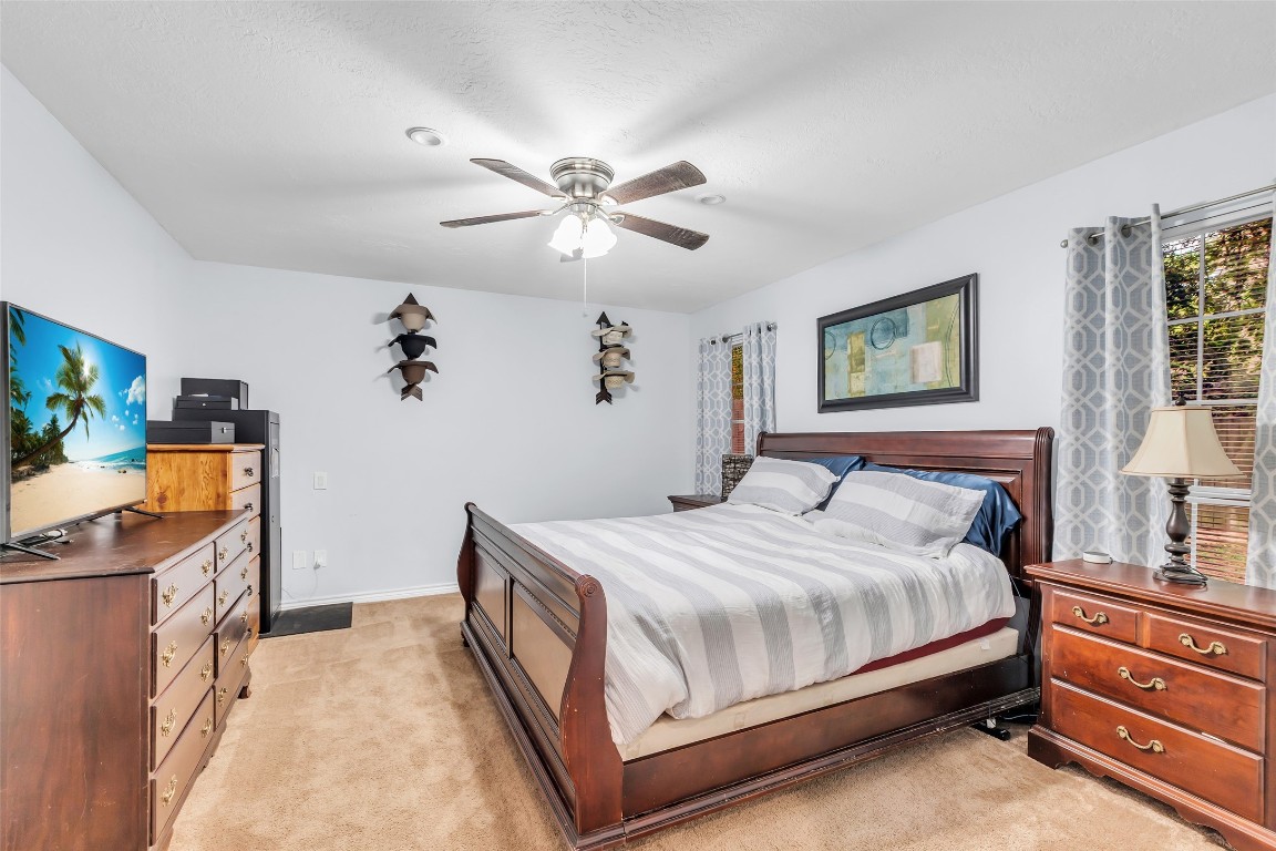 13860 Ventura Road Willis, TX 77318 - Photo 11 of 22 a bedroom with a bed and a chandelier