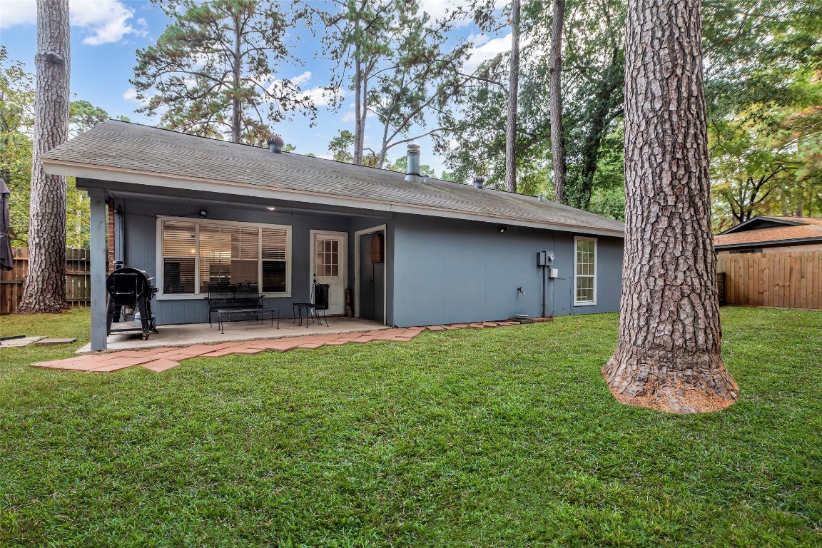 13860 Ventura Road Willis, TX 77318 - Photo 18 of 22 a view of a backyard with table and chairs and a large tree