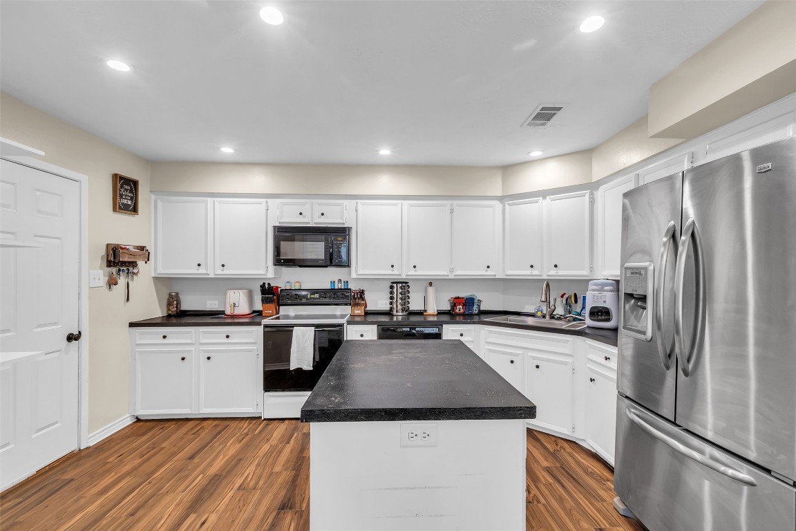 13860 Ventura Road Willis, TX 77318 - Photo 8 of 22 a kitchen with a sink a refrigerator a microwave and cabinets