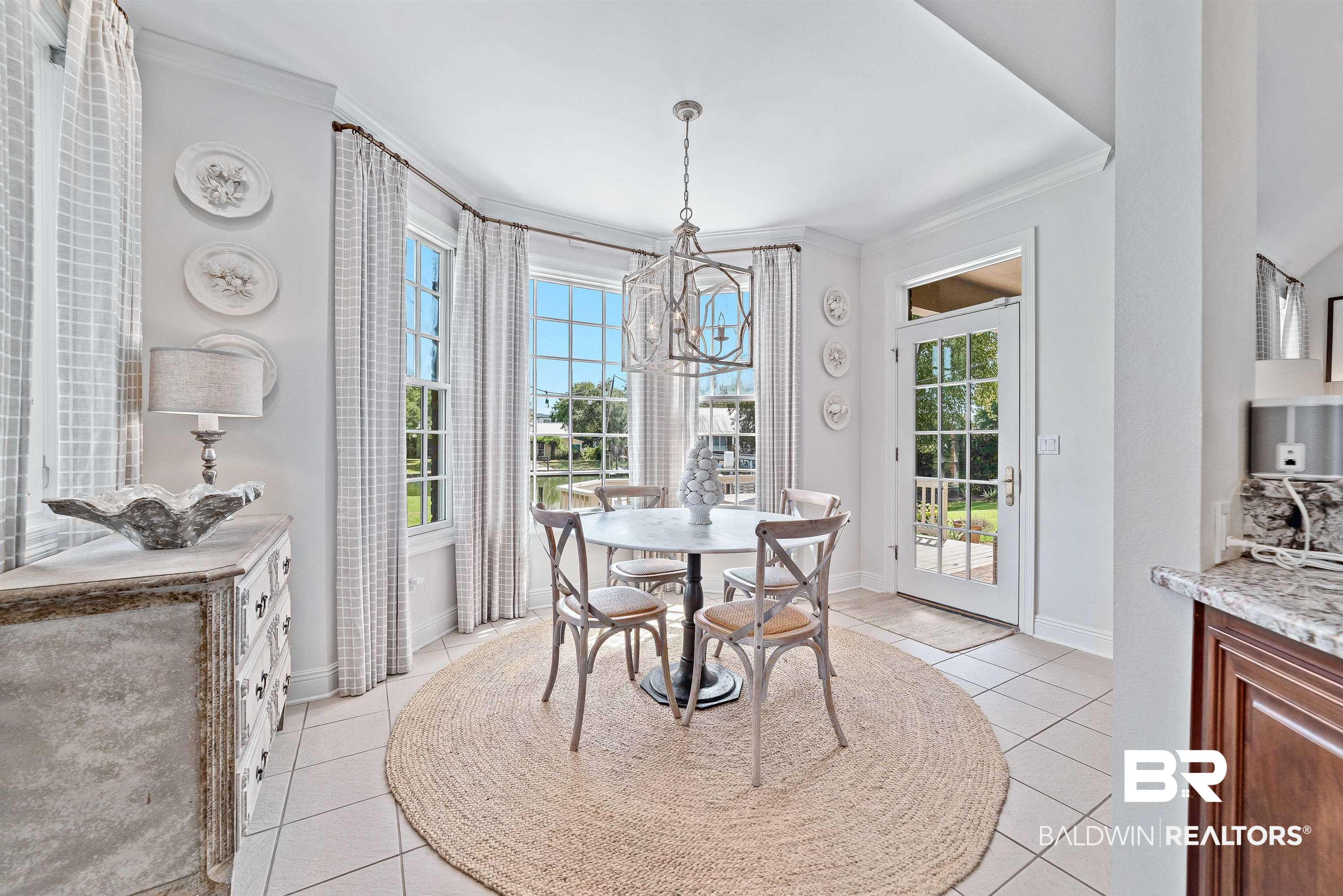 6630 East Quarry Drive Elberta, AL 36530 - Photo 9 of 63 Dining space with crown molding, plenty of natural light, a chandelier, and light tile patterned floors