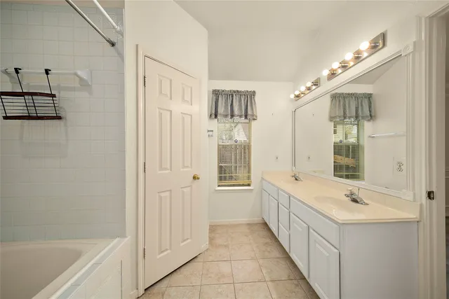 a bathroom with a tub sink and mirror