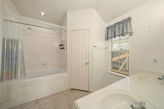 a bathroom with a tub a sink and a shower