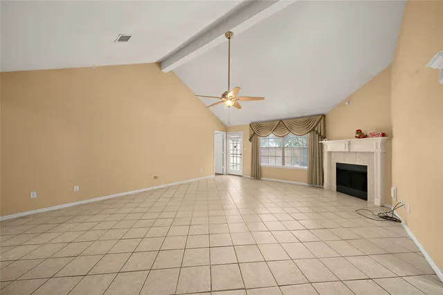 a view of an empty room with a fireplace and a window