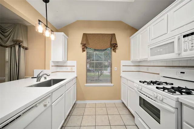 a kitchen with granite countertop a sink and a stove