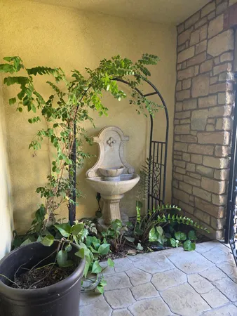 a backyard with table and chairs with potted plants