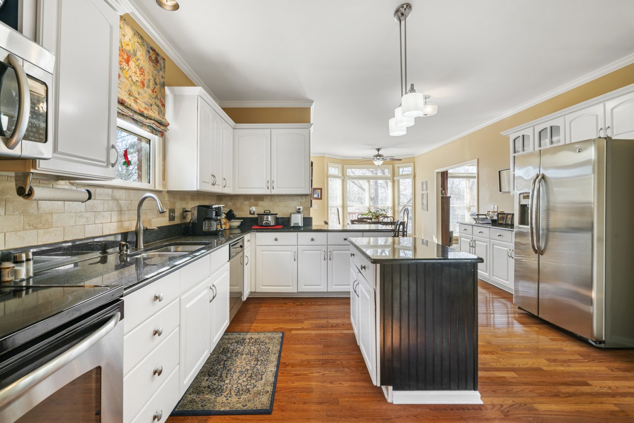 114 Rigby Drive Franklin, TN 37064 - Photo 19 of 55 a kitchen with stainless steel appliances granite countertop a refrigerator a sink dishwasher a stove and white cabinets with wooden floor