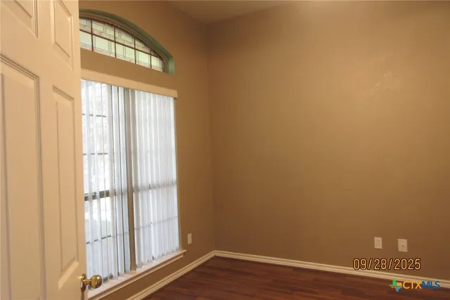 a view of a small space with wooden floor and a window