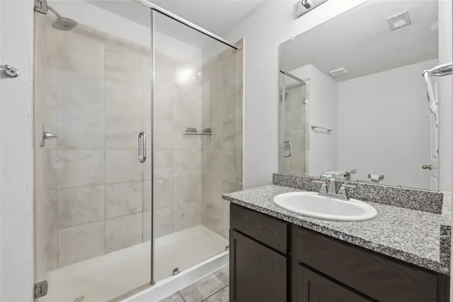 a bathroom with a granite countertop sink a mirror a shower and a bathtub