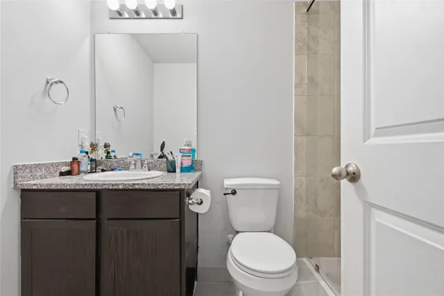 a bathroom with a granite countertop toilet sink and mirror