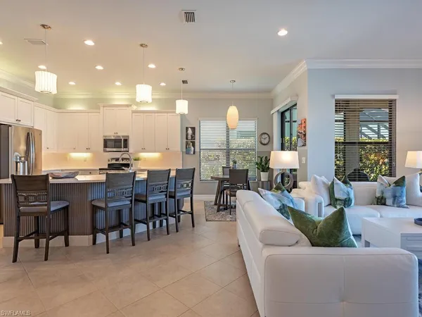 a living room with lots of furniture and kitchen view