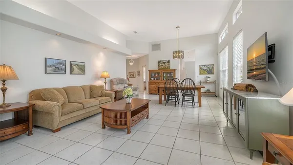 a view of a livingroom with furniture a dinning area hardwood table and windows