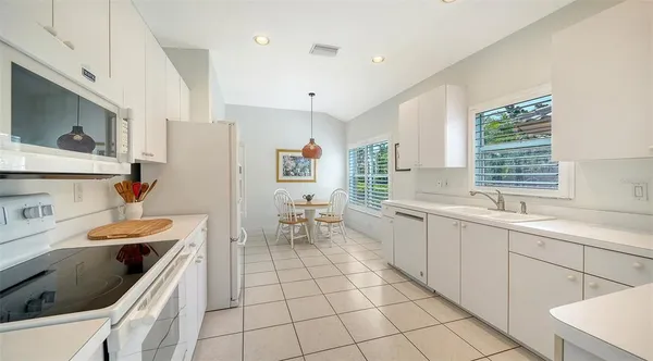 a kitchen with white cabinets stainless steel appliances and a sink