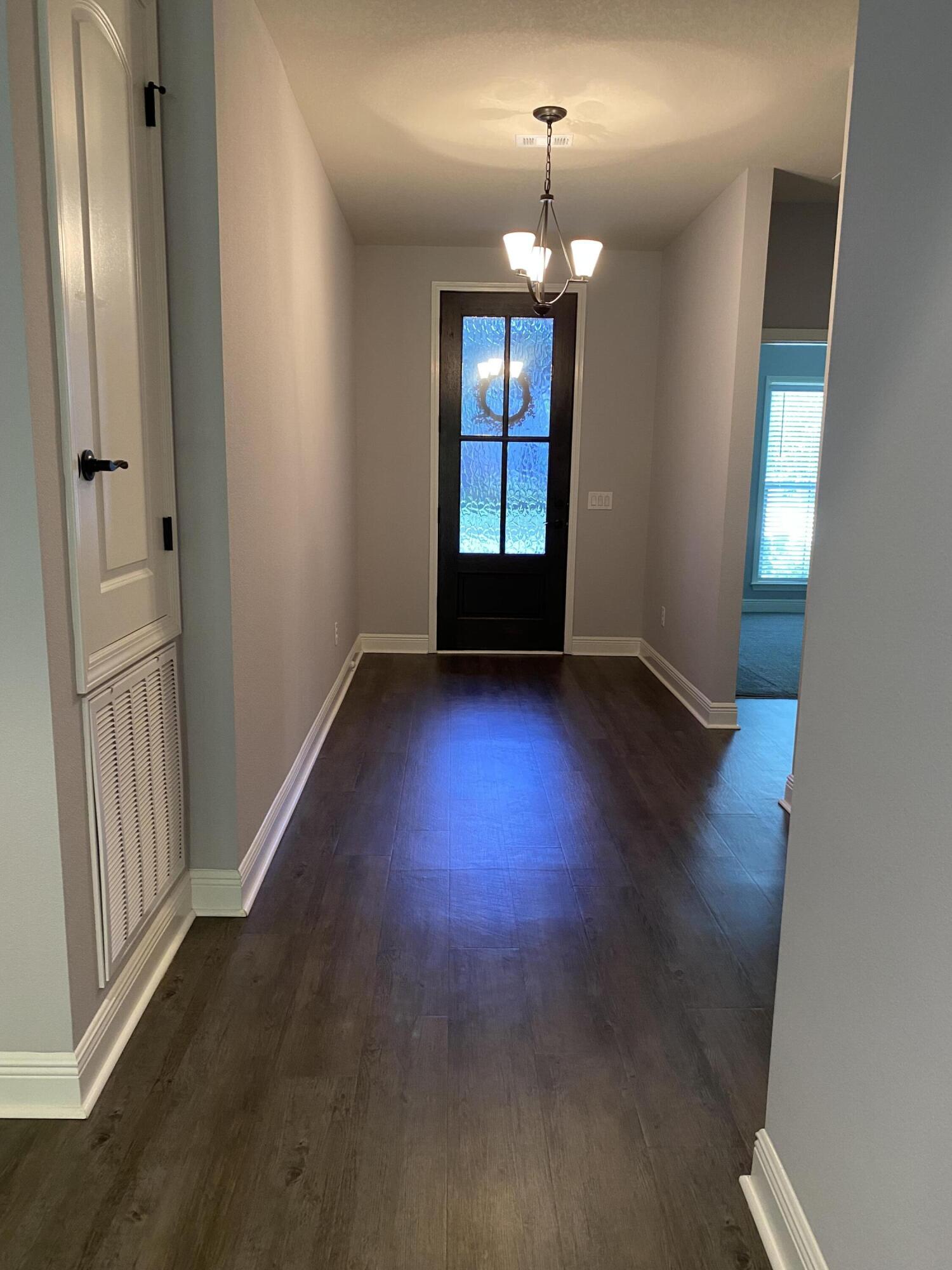 3909 Fielding Court Pace, FL 32571 - Photo 2 of 25 an empty room with wooden floor chandelier and windows