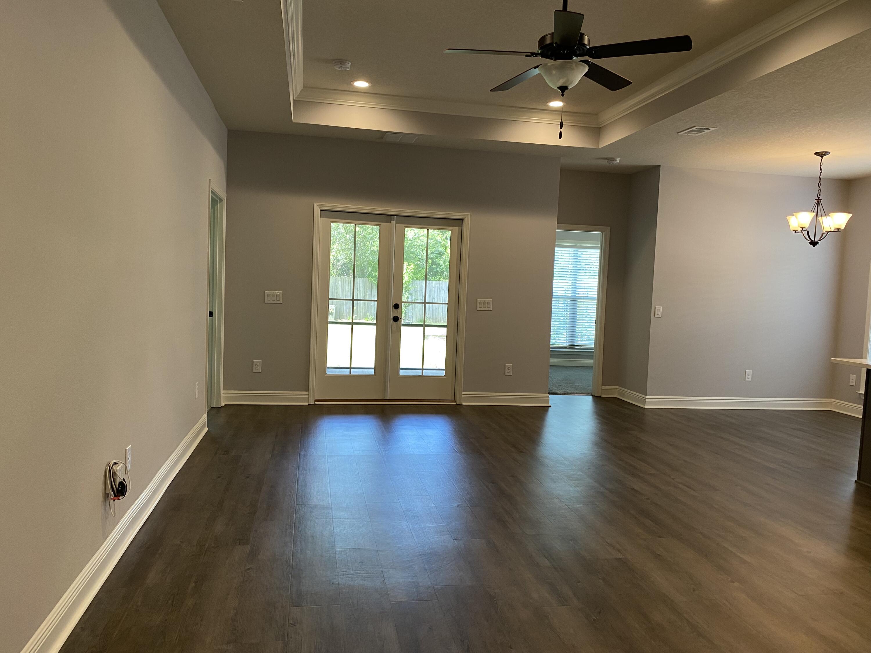 3909 Fielding Court Pace, FL 32571 - Photo 4 of 25 an empty room with wooden floor and windows